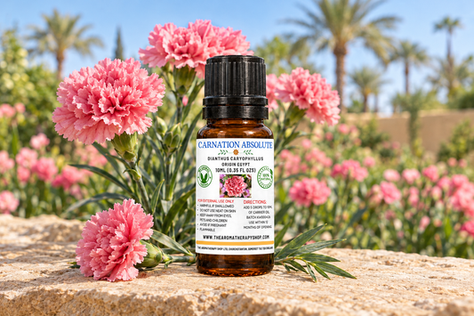 Carnation Absolute showcase with your 10 ml label, pink carnations on warm limestone and an Egyptian garden backdrop